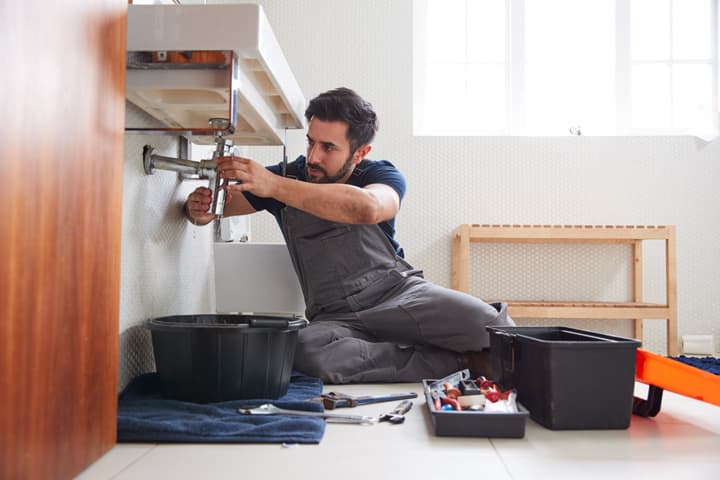 Plumber repairing a sink in a Melbourne home